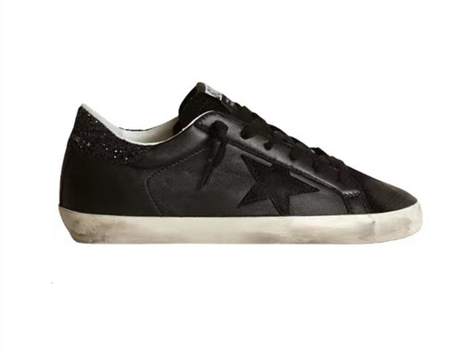 GOLDEN GOOSE حذاء سوبر ستار من جلد النابا الأسود مع نجمة سوداء وعروة كعب لامعة