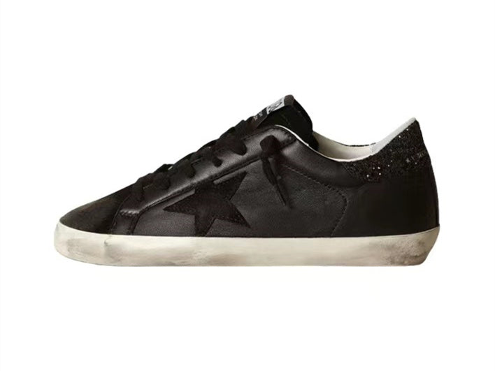 GOLDEN GOOSE حذاء سوبر ستار من جلد النابا الأسود مع نجمة سوداء وعروة كعب لامعة