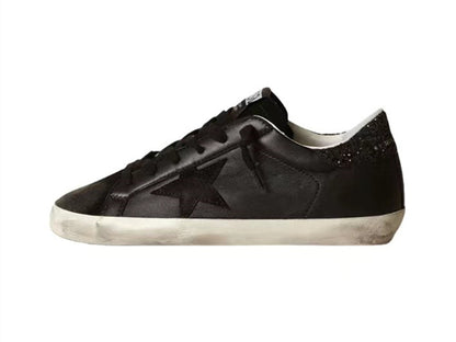 GOLDEN GOOSE حذاء سوبر ستار من جلد النابا الأسود مع نجمة سوداء وعروة كعب لامعة