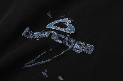 Balenciaga T-shirt featuring intricate, high-density, double-layered 3D embroidery and a washed-denim appliqué.